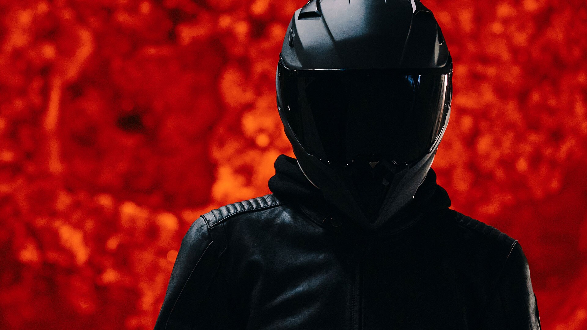 We see a darkly dressed person standing in front of a red-hot steel boiler.